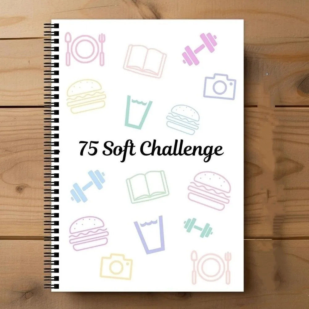 A spiral-bound notebook page featuring various icons like a hamburger, book, camera, and weights for a soft challenge planner