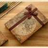 A vintage-style leather box containing a map and an antique fountain pen set with a brown ribbon tied around it.