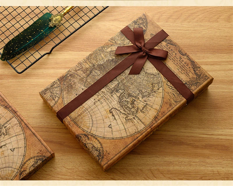 A vintage-style leather box containing a map and an antique fountain pen set with a brown ribbon tied around it.