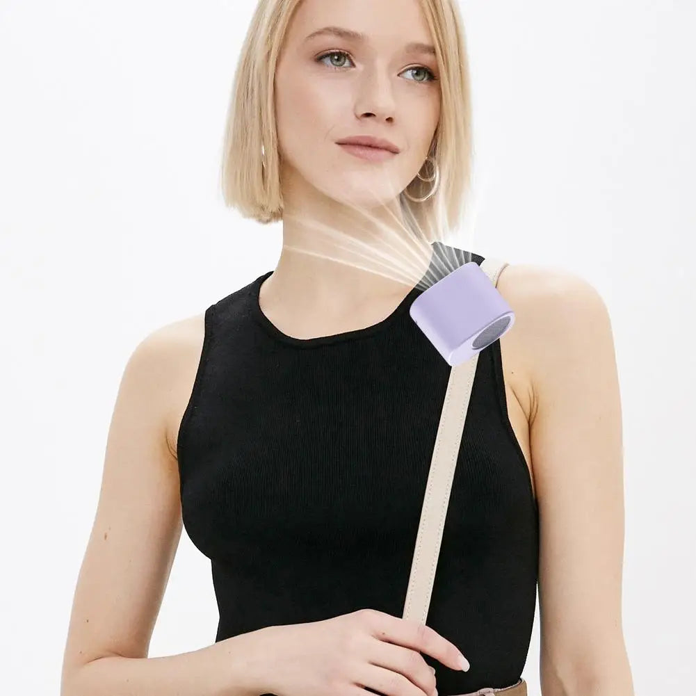 A woman is holding a black top and a white cord with a purple clip-on cooling fan attached.