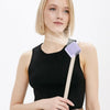 A woman is holding a black top and a white cord with a purple clip-on cooling fan attached.
