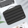 A dark gray protective laptop sleeve bag with reinforced padding resting on a light surface next to a laptop.