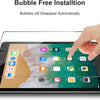 A hand places a bubble-free installation of a tempered glass screen protector onto an iPad display.