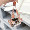 A rose gold diamond butterfly watch strap is displayed hanging from a watch and a separate charm.