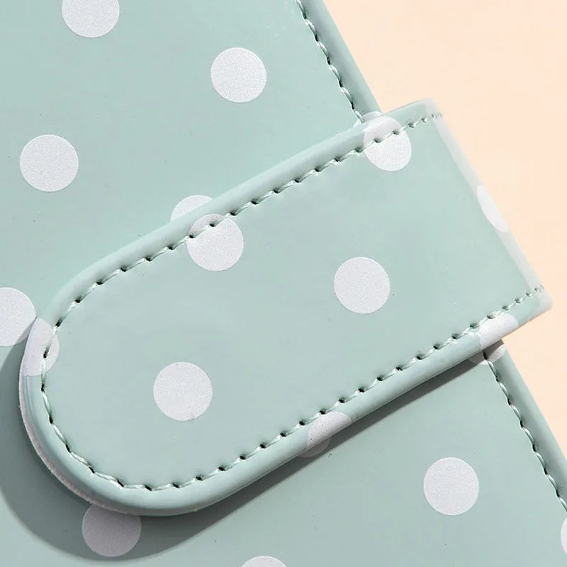 A light mint green reusable PU leather binder with white polka dots and stitched edges.
