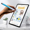 A hand is using a blue stylus pen to write on an iPad screen displaying a furniture design plan.