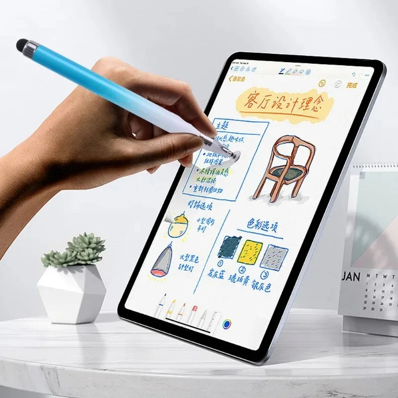 A hand is using a blue stylus pen to write on an iPad screen displaying a furniture design plan.