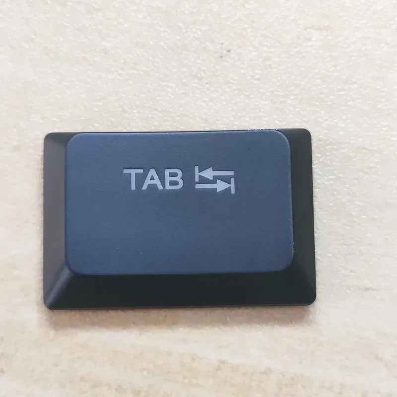 A dark blue replacement keycap labeled TAB with an arrow icon for a Dell Alienware keyboard.