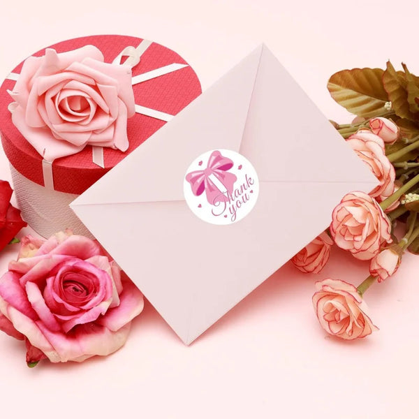 Pinke Dankesbänder für Scrapbooking neben einer rosa Rose und einer roten Geschenkbox