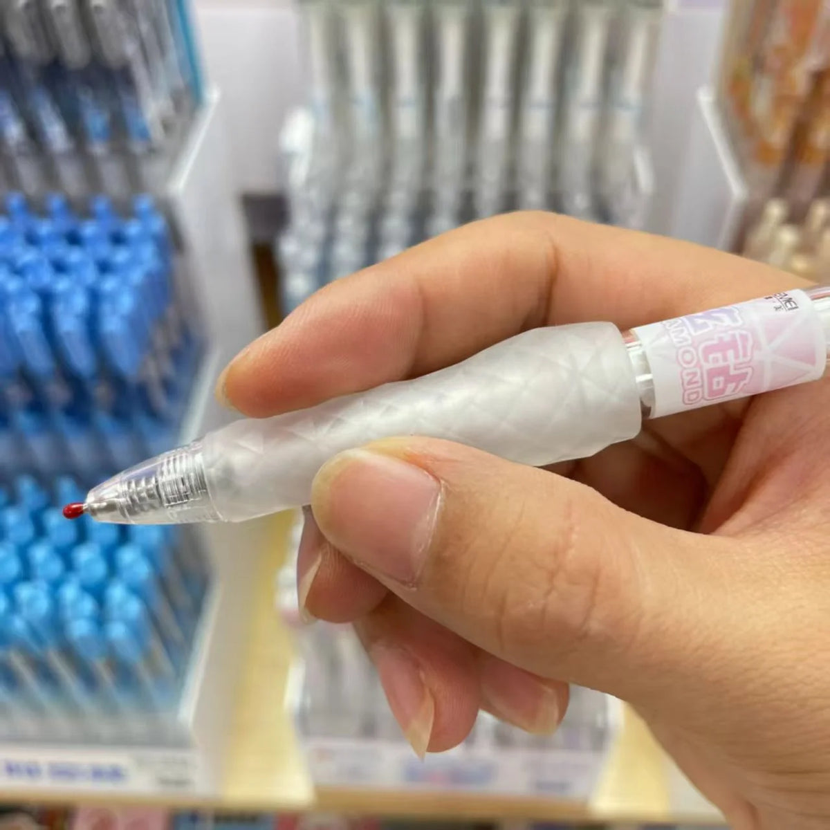 Eine Hand hält einen klaren Gelstift aus einem Set von Premium-Fidget-Spinner-Stiften.