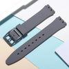 A gray silicone watch strap is shown alongside replacement tools on a light background.