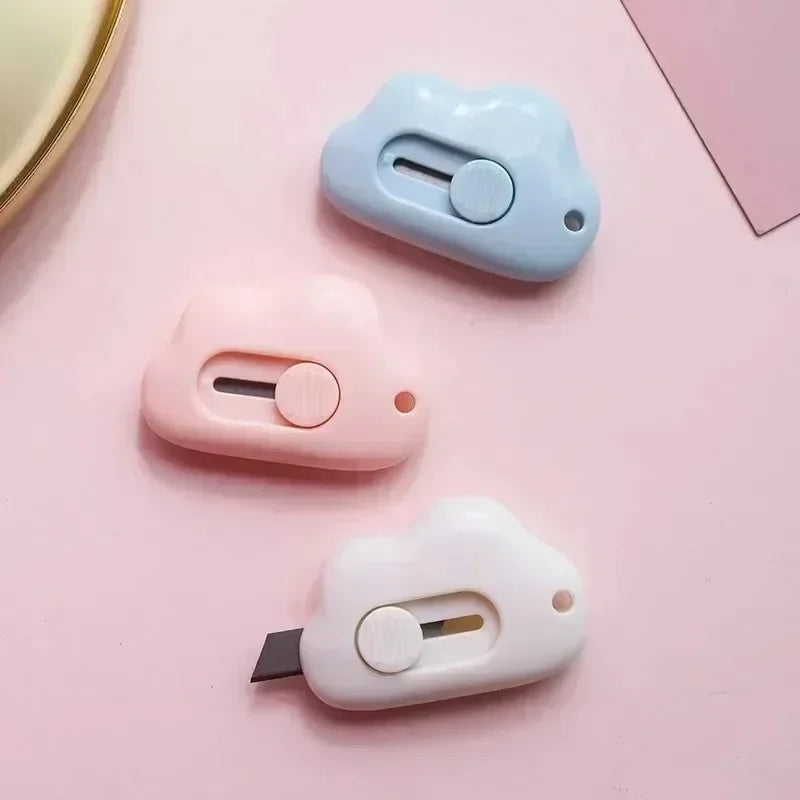 Three pastel-colored portable rabbit cloud letter openers and crafting tools are displayed on a pink surface.