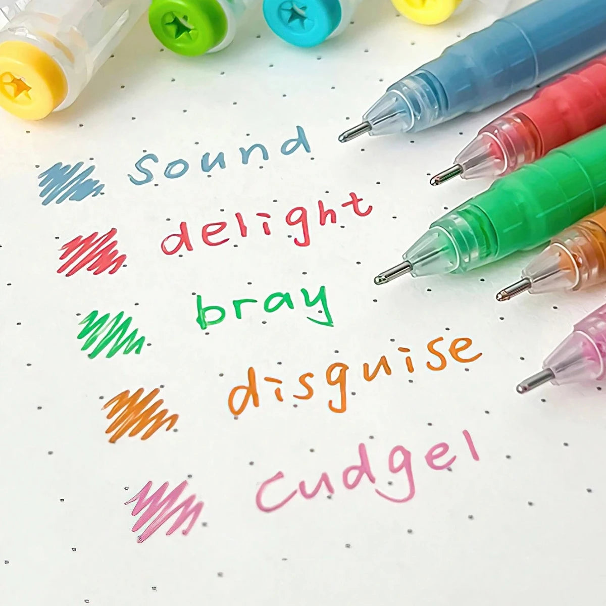 A collection of multi-colored gel pens writing various words like sound delight bray disguise and cudgel on white paper.
