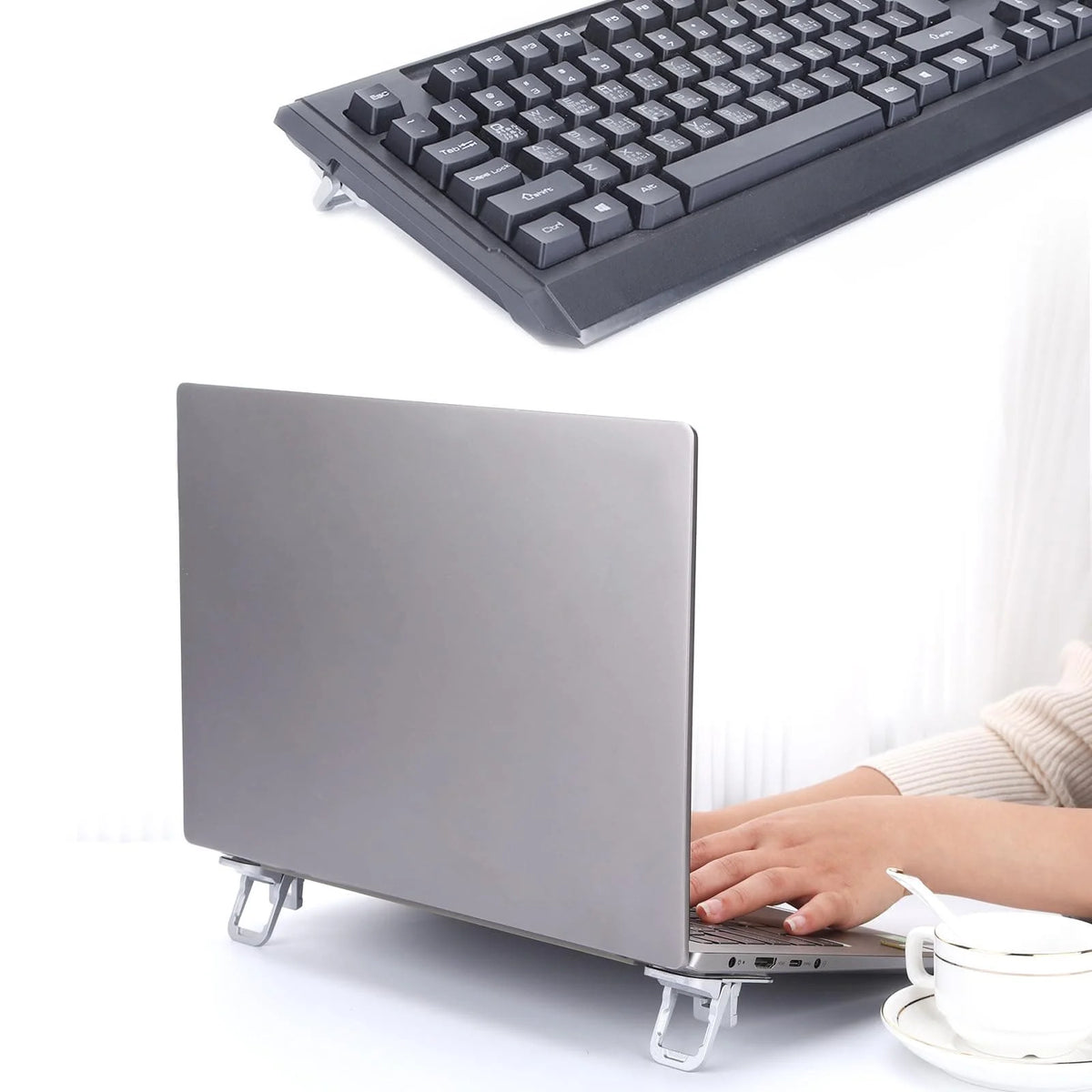 Un ordinateur portable argenté est soutenu par un support pliable, montrant la configuration du clavier et de l'écran.