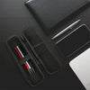 A black compact EVA hard shell pencil case with mesh pockets and a silver pen resting on a dark surface.