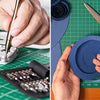 Hands are shown using a double-sided self-healing cutting mat for crafting and sewing on various materials.