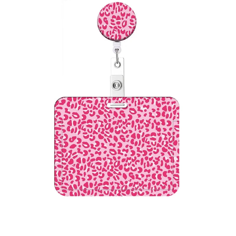 A pink leopard print retractable badge holder with a circular clip.