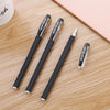 A pack of black gel ink pens with silver accents lying on a light wooden surface.