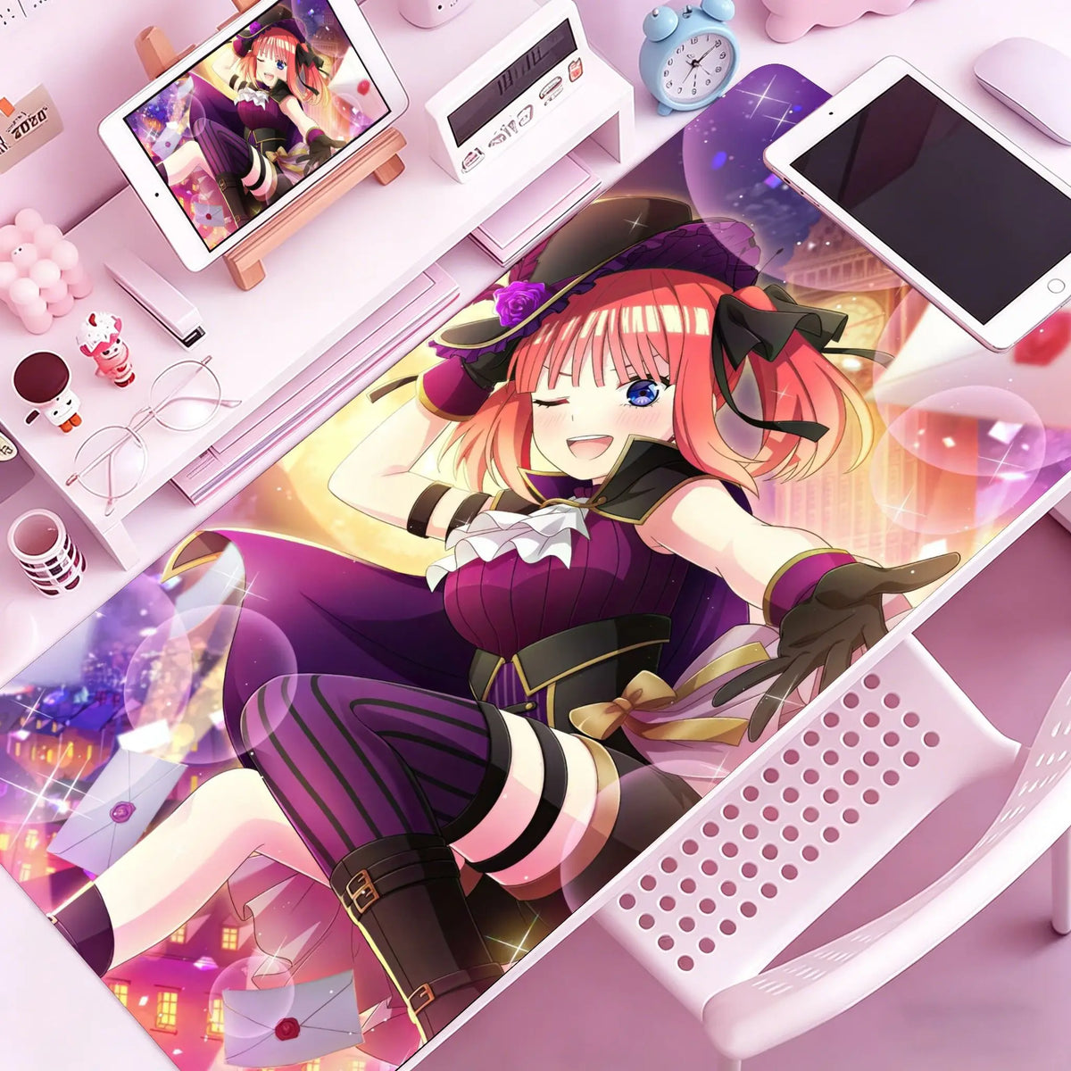 A vibrant illustration of an anime girl with pink hair wearing a purple outfit sitting on a desk mat next to a computer and a