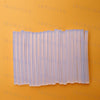 A pack of clear hot melt glue sticks arranged in a row on an orange background.
