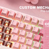 A close-up of a pink mechanical keyboard featuring custom pre-lubed switches and a cocoa cream V2 keycap.