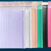 A row of purple padded bubble mailers in various colors including white, pink, black, and yellow.