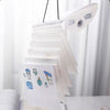 A stack of transparent storage books for stickers and documents hanging on a rack.