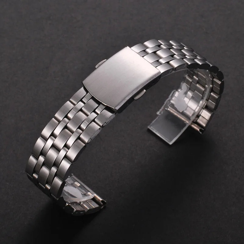 A stainless steel watch band with a folding safety clasp shown on a dark background.