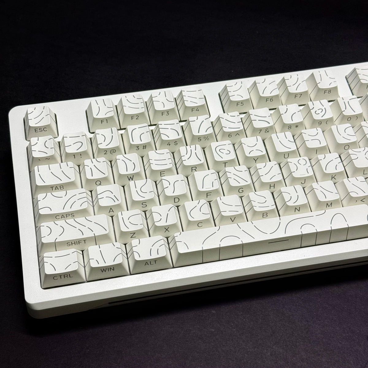 Vista cercana de teclas de contorno blancas en degradado para teclado mecánico, mostrando varias teclas de función y modifica