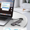 A silver 7-in-1 USB-C docking station is shown next to a laptop, demonstrating its high-speed connectivity features.