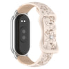 A beige silicone watch band with a silver casing and black face, featuring 3D engraved flowers.