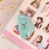 A light blue cat paw mini cutter tool is shown on a pink craft notebook next to illustrations.