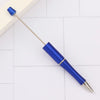 A blue DIY beadable pen with a gold tip is shown on a white tiled surface.