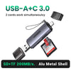 Lector de tarjetas USB-A a C plateado con carcasa metálica y cable, diseñado para tarjetas SD y TF simultáneas.