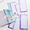A stack of A6 budget planner binders featuring purple and blue patterned paper with spiral binding.