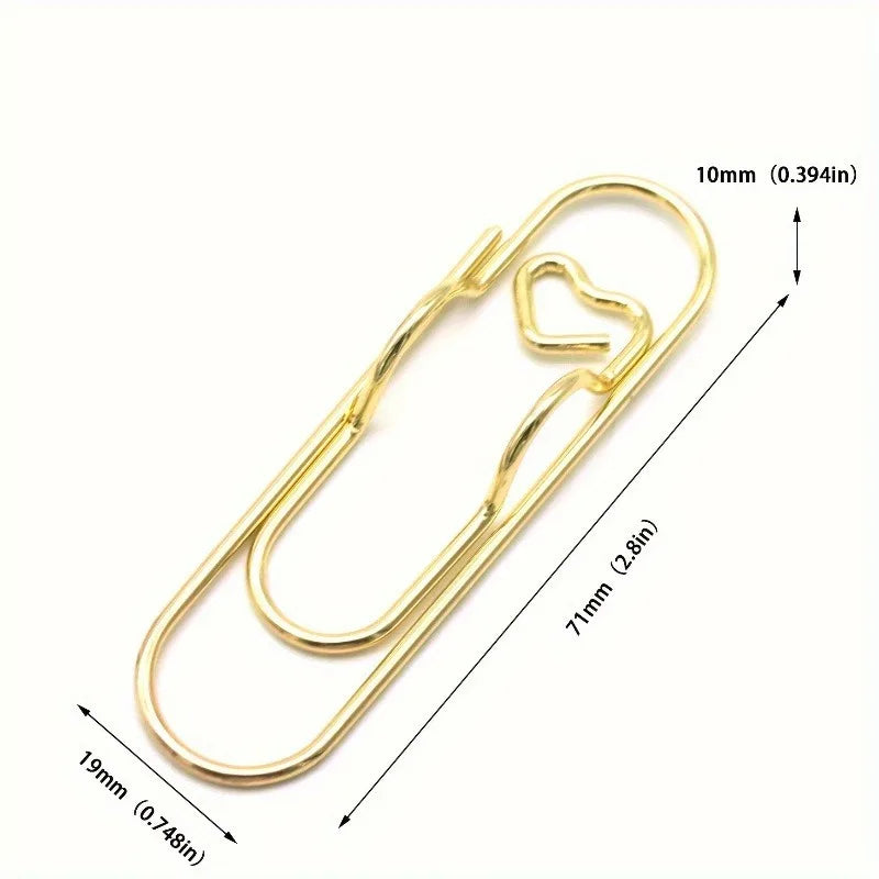 Un juego de cuatro clips para bolígrafos multifuncionales de color dorado con aberturas en forma de corazón, sobre fondo blan