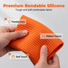 A hand holds an orange silicone fabric product showing its ribbed texture and soft touch.
