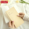 A hand holds an open weekly planner journal with a timeline graphic on a white background.