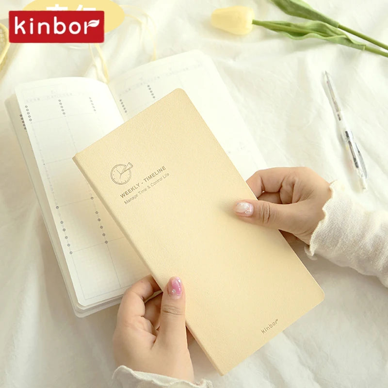 A hand holds an open weekly planner journal with a timeline graphic on a white background.