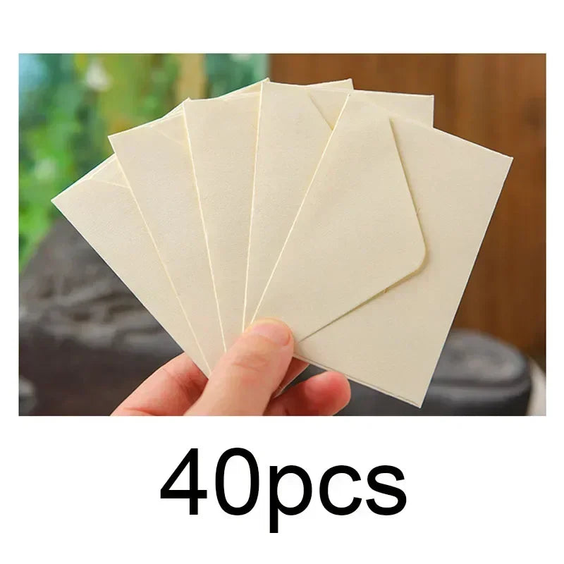 Una mano sostiene una pila de 40 sobres vacíos kraft para invitaciones de boda.