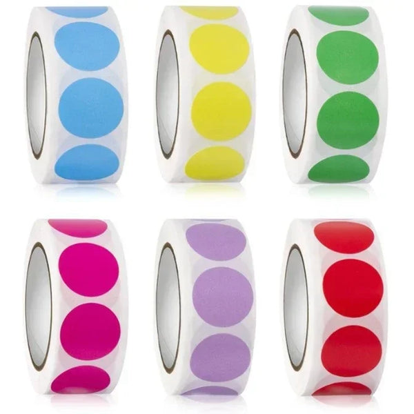 A collection of round dot labels in various colors including blue, yellow, green, and pink on white rolls.