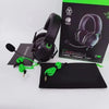 Black Razer BlackShark V2 X gaming headset with black earcups and a green cord displayed on a black box.