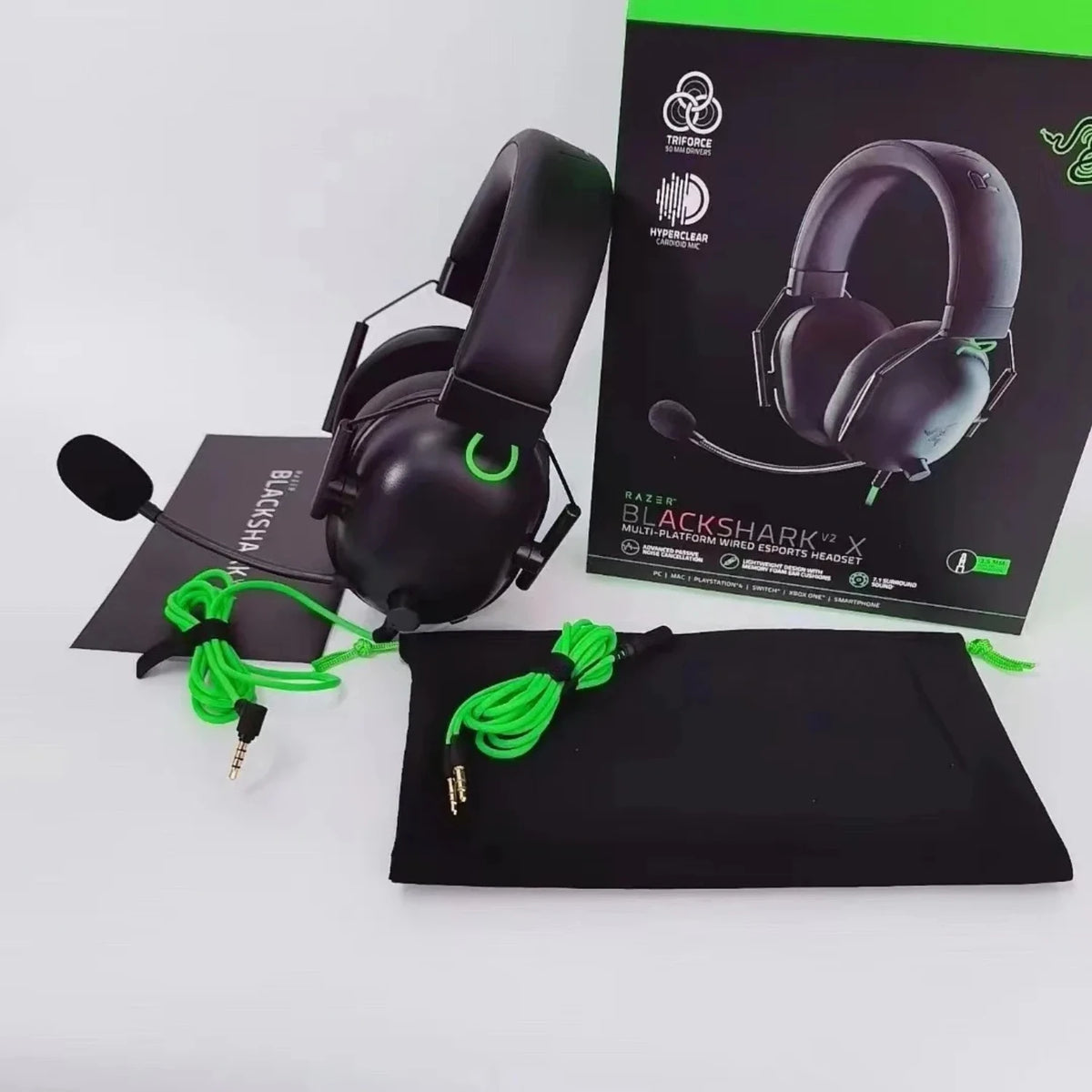 Black Razer BlackShark V2 X gaming headset with black earcups and a green cord displayed on a black box.