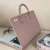A pink laptop sleeve with a handle is shown next to a silver mirror and a small zippered pouch.