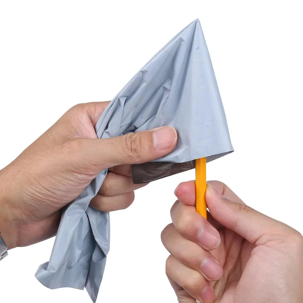 A hand is holding a gray dustproof mailing bag shaped like a cone with an orange sealing stick.