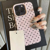 A pink polka dot textured phone case with a soft-touch grip is displayed against a dark background.