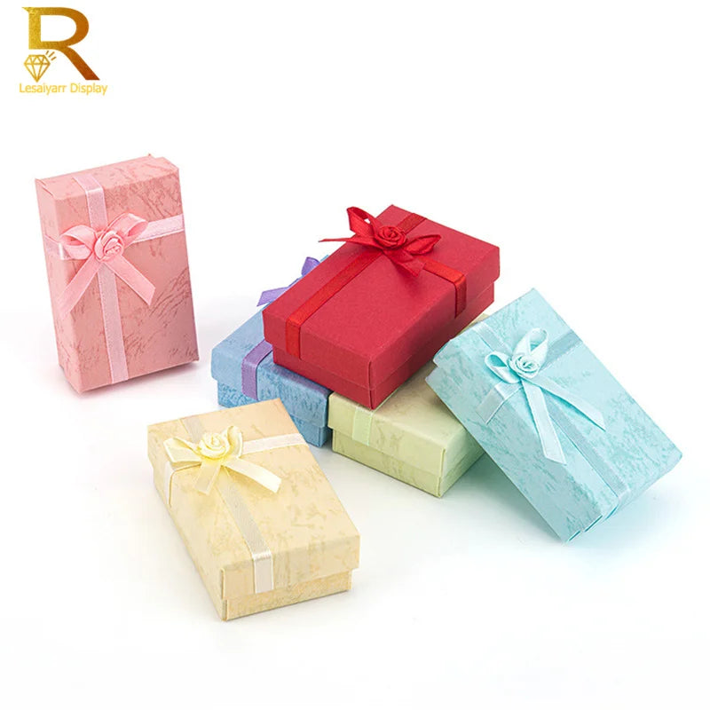 A set of four jewelry gift boxes in pink, red, blue, and green colors with ribbon accents.