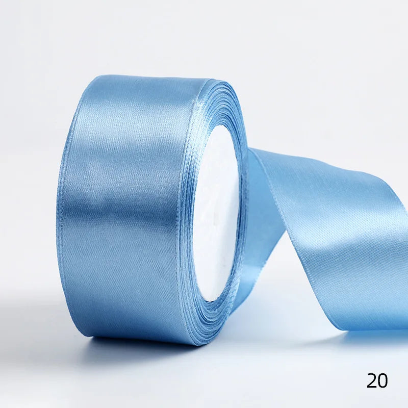 A roll of light blue satin ribbon used for gift wrapping or DIY crafts.