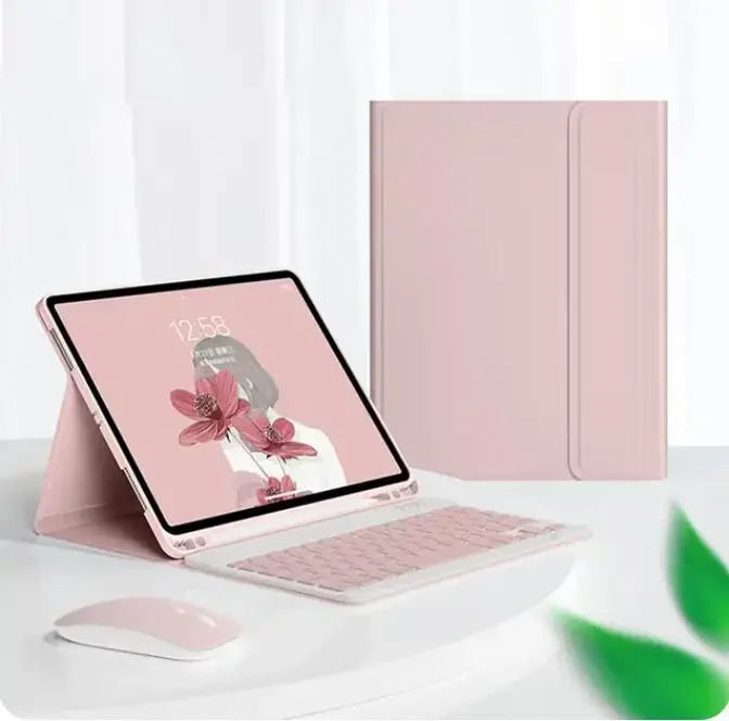 A pink magnetic keyboard case for an iPad Pro is shown next to a laptop and a mouse on a white surface.