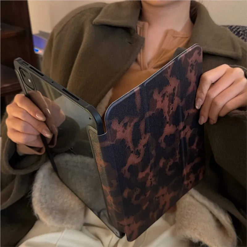 Eine Person hält eine braune Lederhülle für ein iPad mit Leopardenmuster.